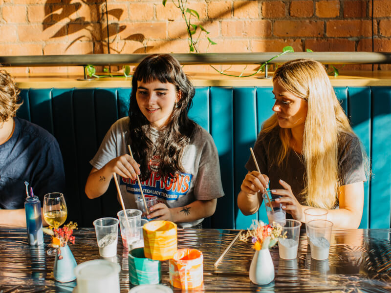 Two young women surrounded by paints at a painting class
